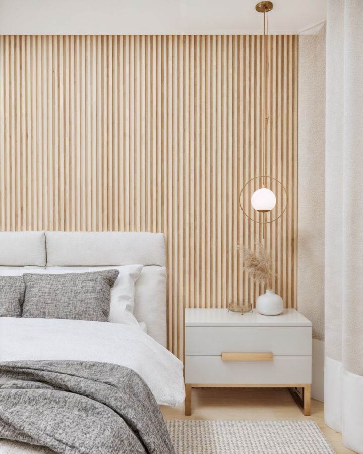 Painel de madeira ripada atrás da cama na Suíte Master da residência AlphaJ08, conferindo aconchego ao ambiente projetado pelo Studio Caju Arquitetura.
